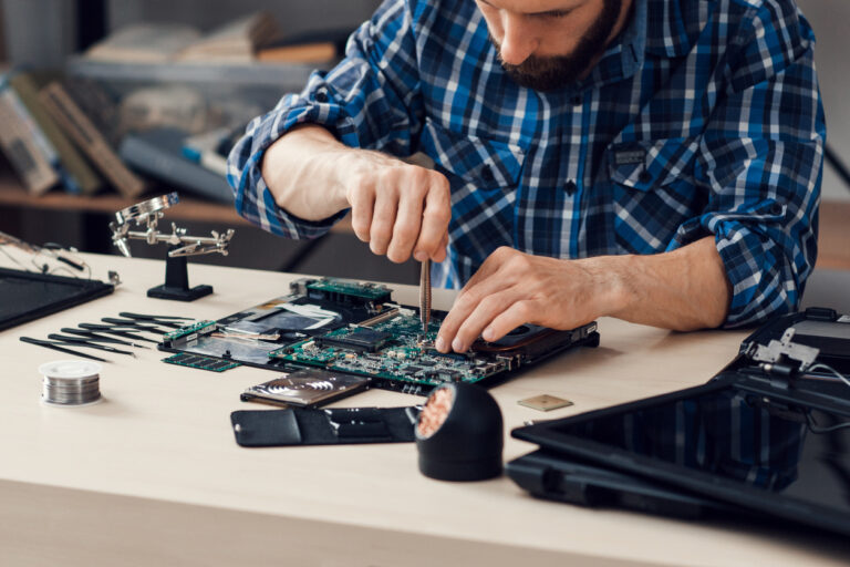 Laptop disassembling with screwdriver at repair shop