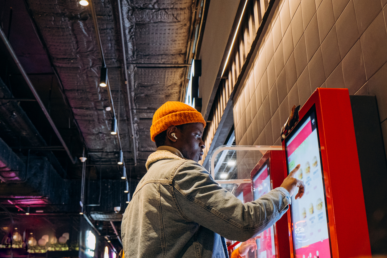 African-American man uses self-service kiosk to place an order